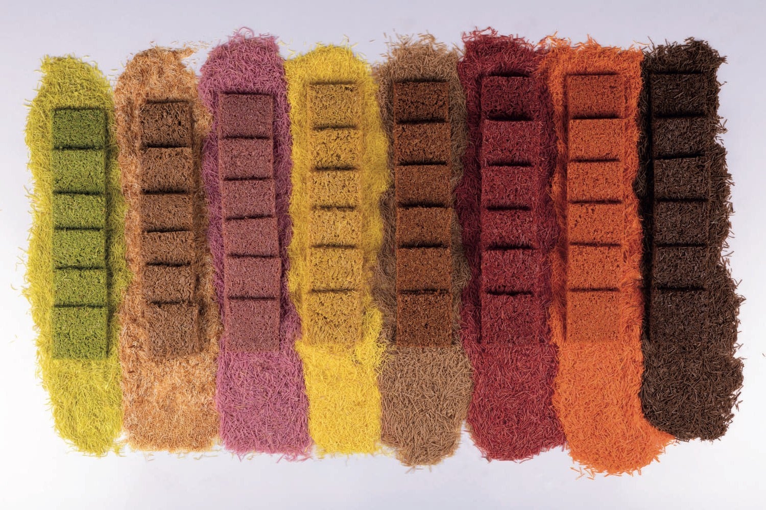 Eight rows of coloured kadayif strands with squares of coloured kadayif dessert